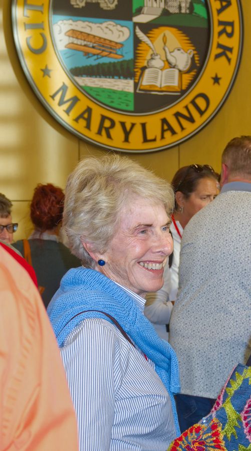 Woman with a warm smile beneath the City of College Park seal
