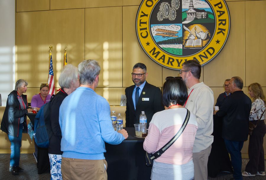Guests mingling under the City of College Park seal